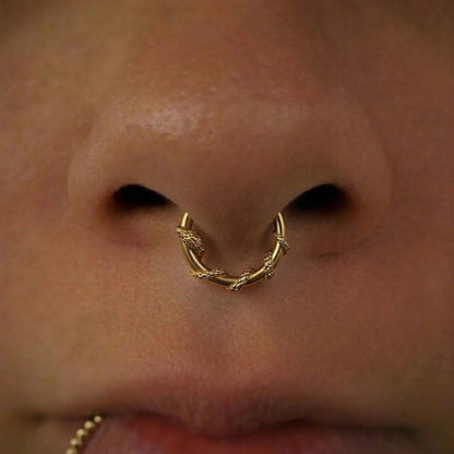Gold-tone Ouroboros Serpent clicker worn in a septum piercing, close view of the twin snake motif