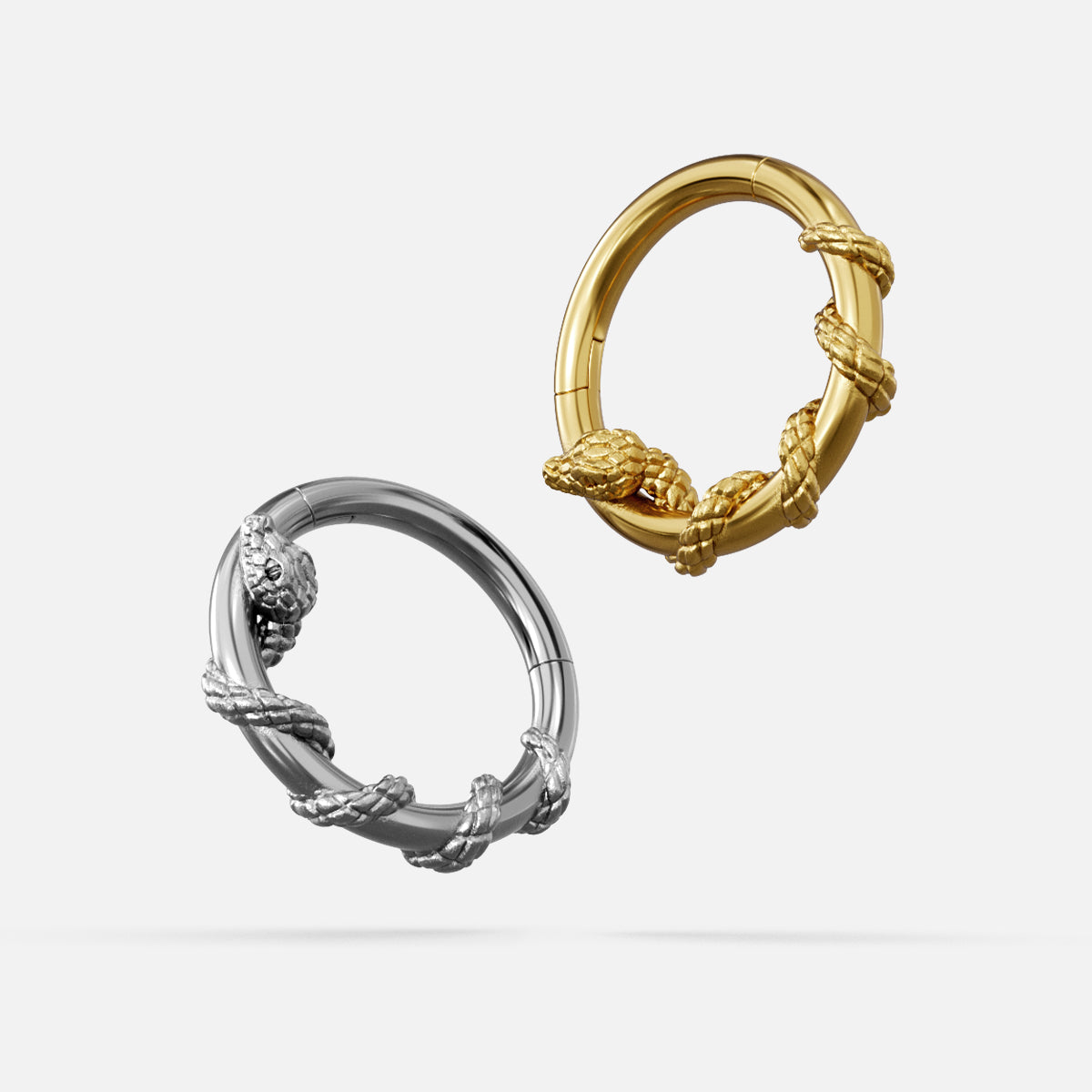 Silver and gold Ouroboros Serpent clickers shown open and lying flat