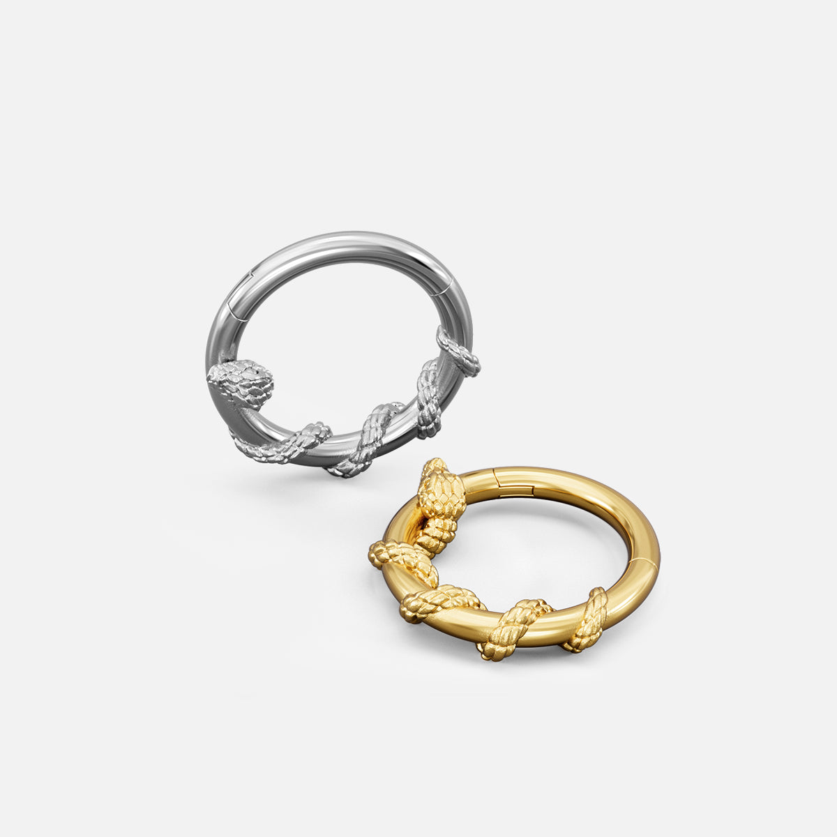 Silver-tone and gold-tone Ouroboros Serpent clickers shown together with textured coiled snake details