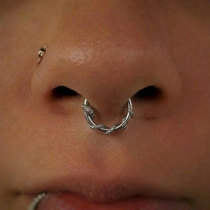 Silver-tone Ouroboros Serpent clicker worn in a septum piercing, close view of the coiled snake design
