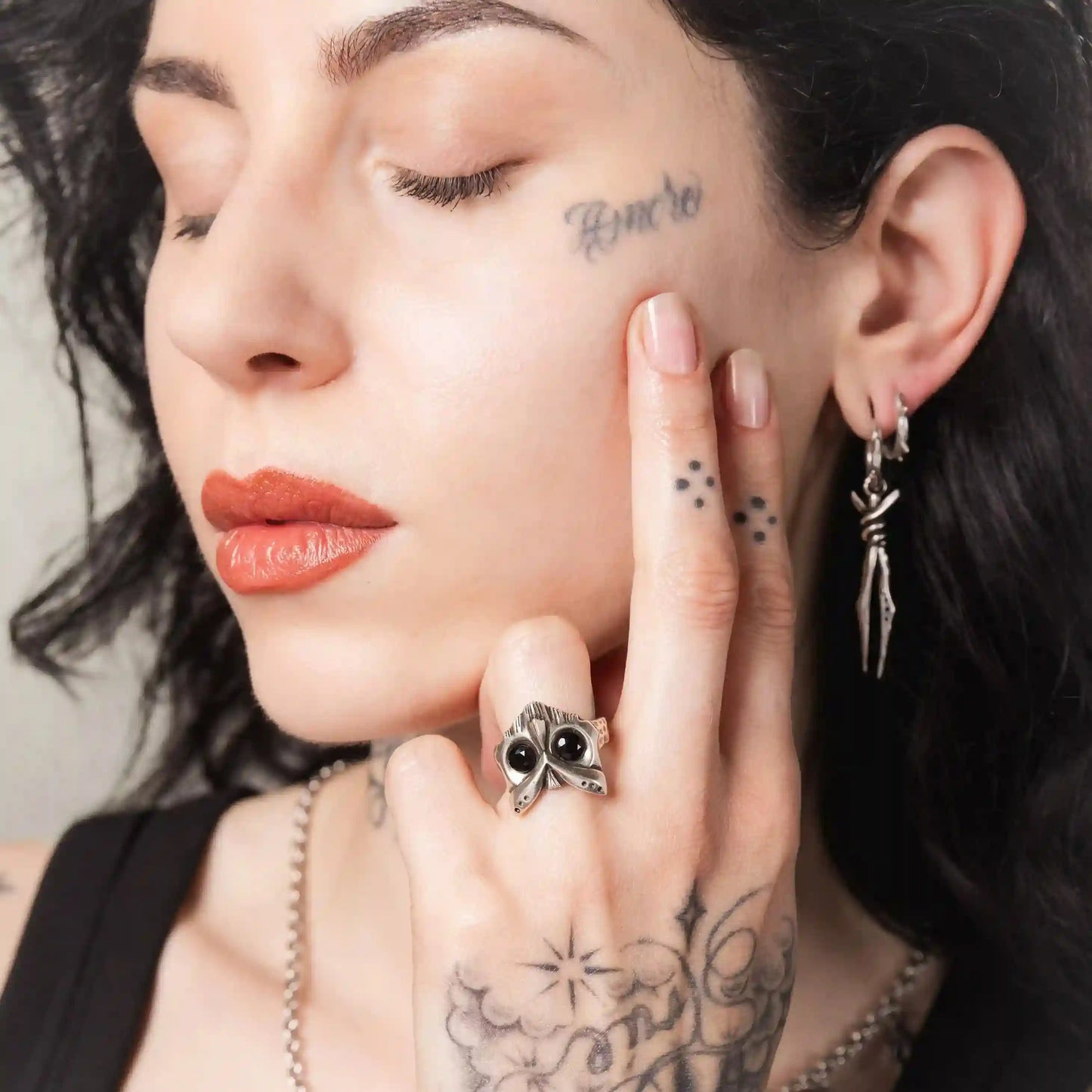 Close-up of Owl Sentinel Rings worn on hand with antiqued silver owl skull and stone eyes