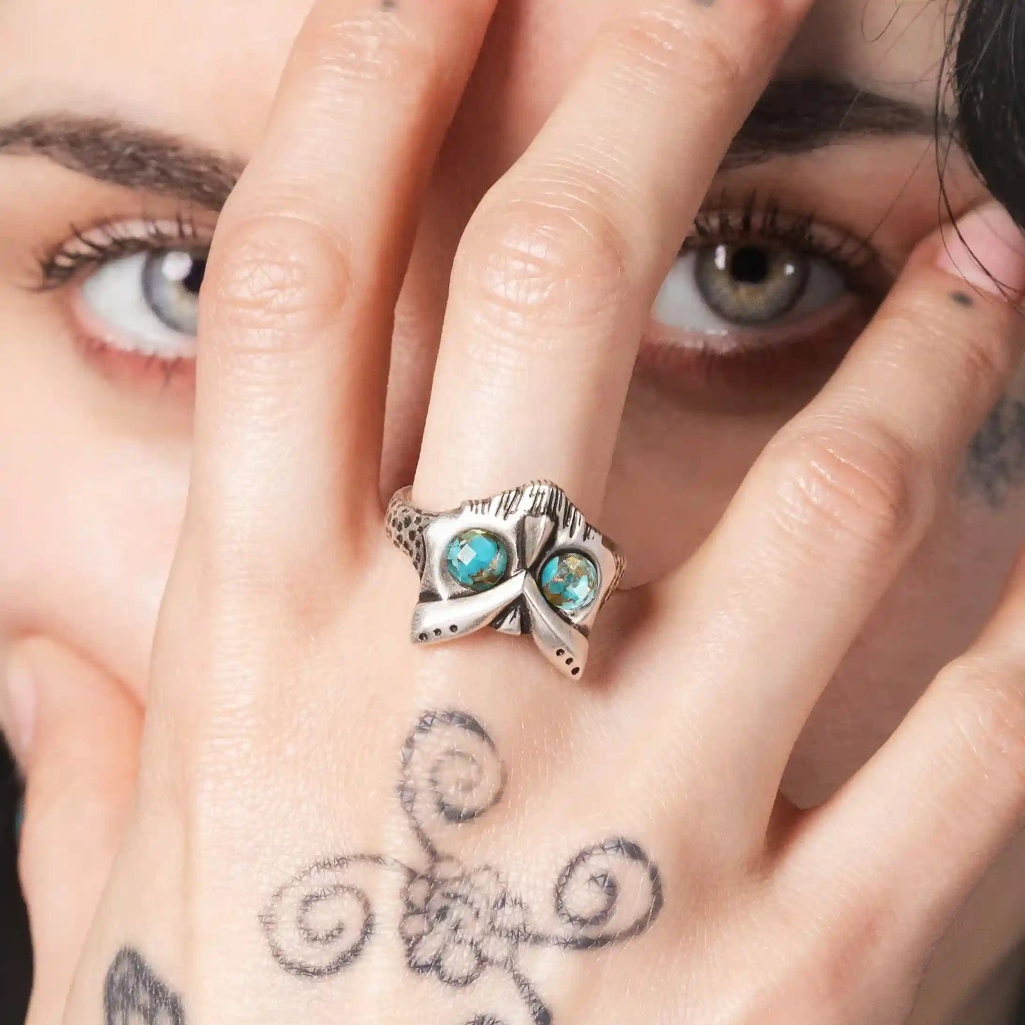 Model wearing Owl Sentinel Rings with turquoise stone eyes and antiqued silver owl skull design