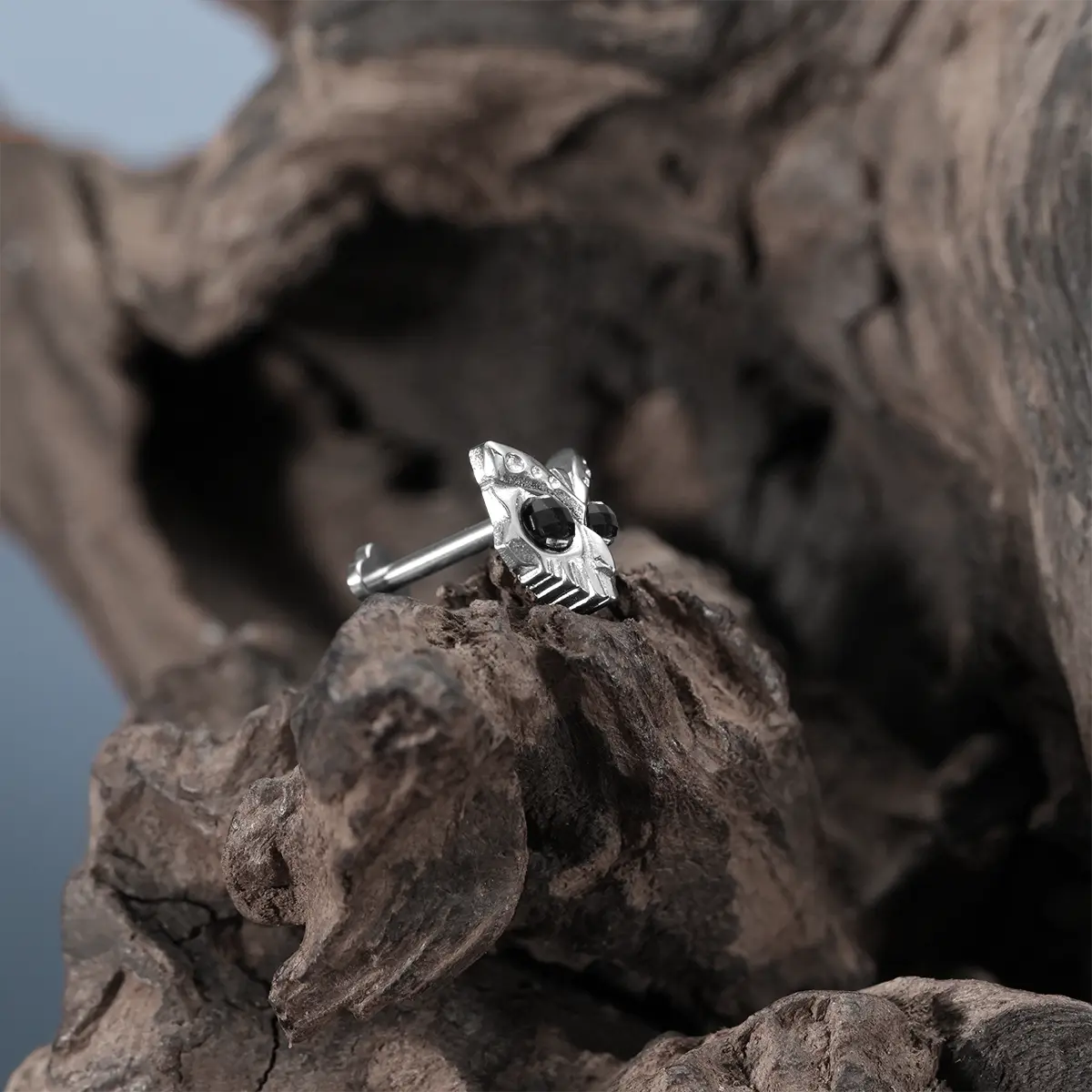 Silver Owl Skull Ear Studs displayed on driftwood with dark woodland jewelry styling