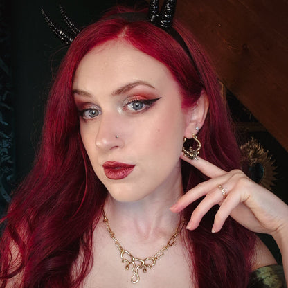 Red-haired model wearing a gold Passionate Heart hoop earring
