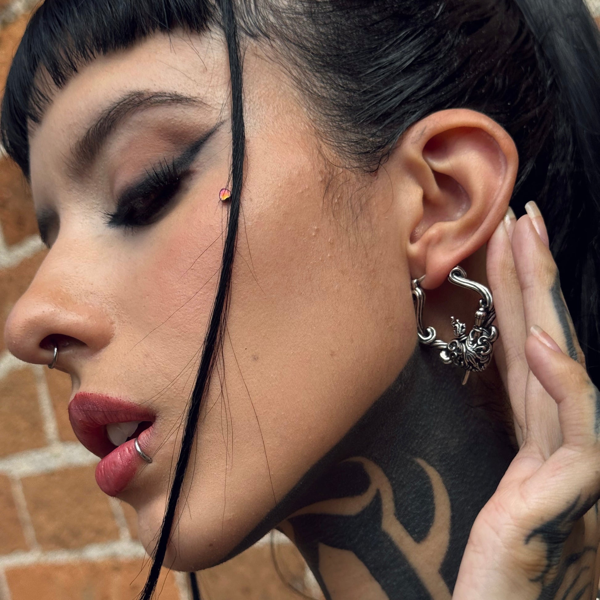 Close-up of model wearing a silver Passionate Heart hoop earring