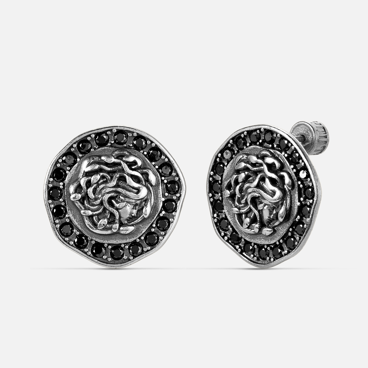 petrified nocturne ear studs in silver shown in a front view, featuring medusa-inspired stud earrings framed with obsidian details