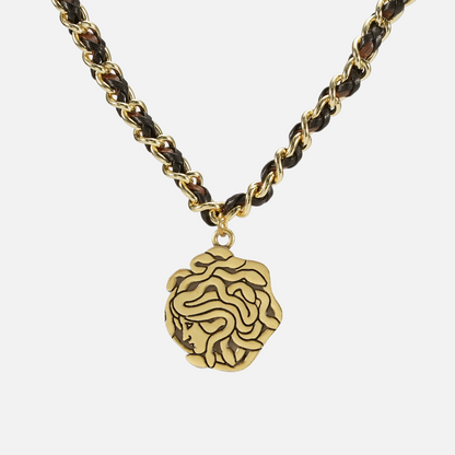 petrified power necklace in gold shown in a back view, featuring a medusa-inspired pendant on a braided chain