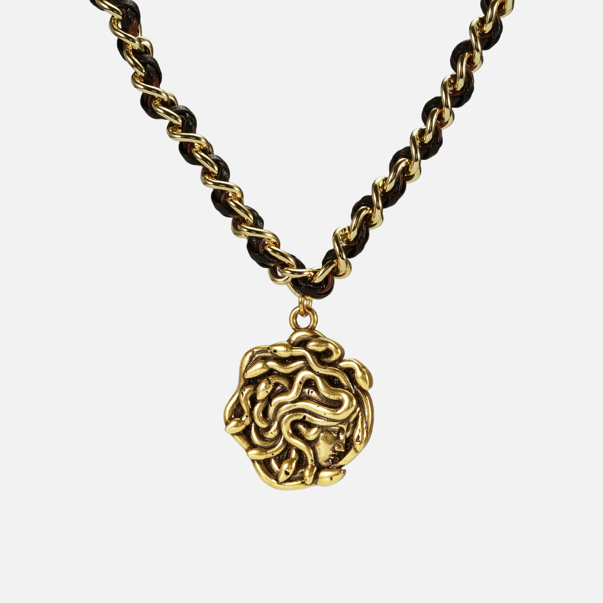 petrified power necklace in gold shown in a front close-up view, featuring a medusa-inspired pendant on a braided chain