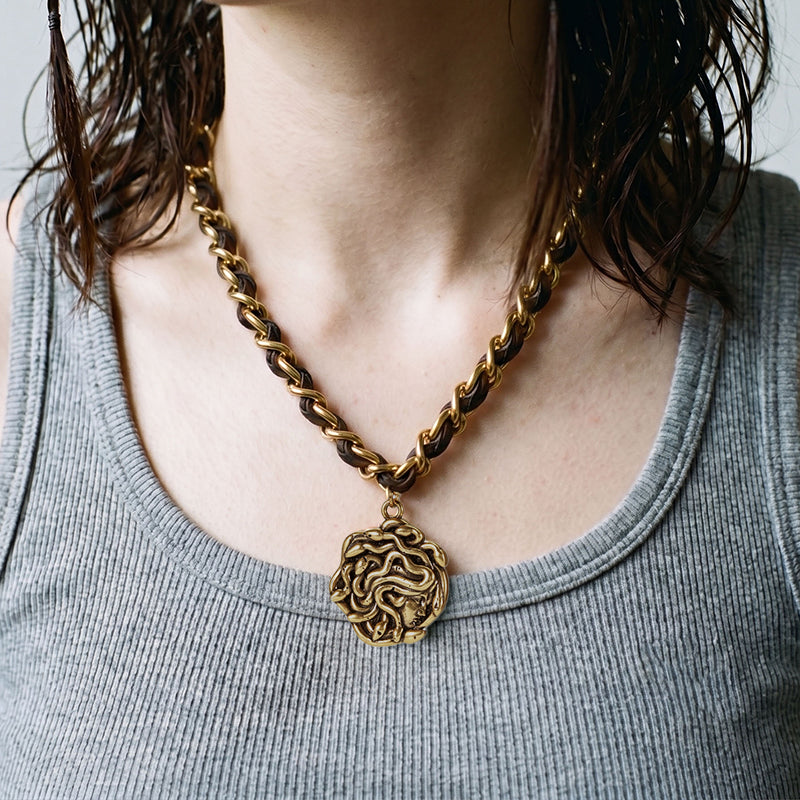 petrified power necklace in gold shown on neck, featuring a medusa-inspired pendant on a mixed-chain necklace