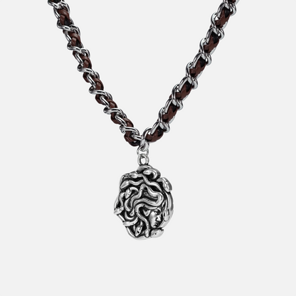 petrified power necklace in silver shown in an angled close-up view, featuring a medusa-inspired pendant on a braided chain