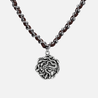 petrified power necklace in silver shown in a front close-up view, featuring a medusa-inspired pendant on a braided chain