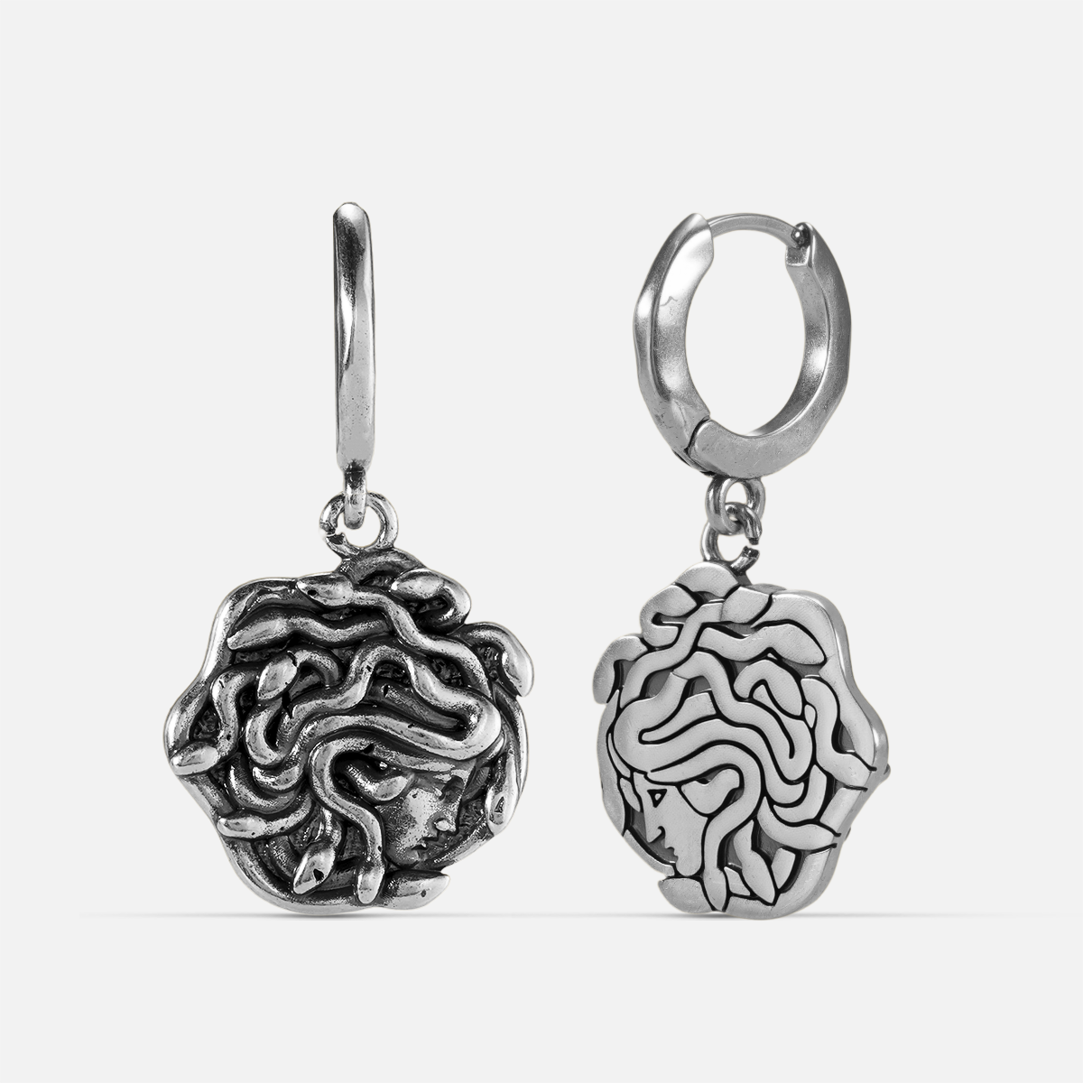 petrifying gaze dangle earrings in silver shown in a front and back view, featuring medusa-inspired drop charms suspended from small hoops