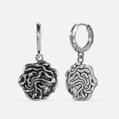 petrifying gaze dangle earrings in silver shown in a front and back view, featuring medusa-inspired drop charms suspended from small hoops