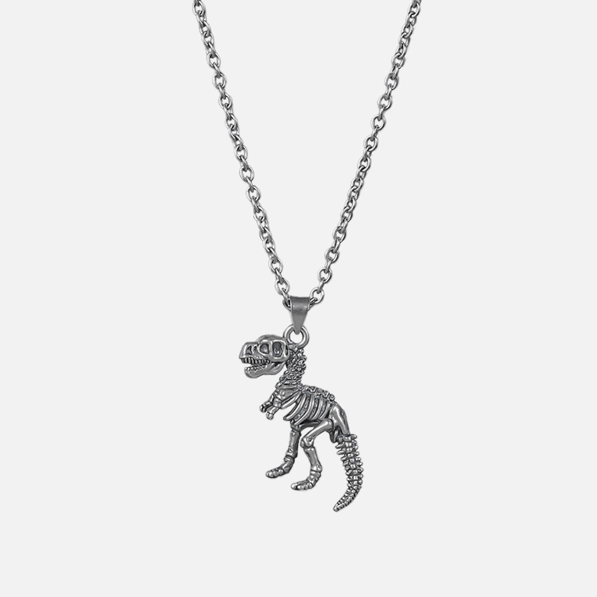 Silver-tone chain necklace with a dinosaur skeleton pendant shaped like a T-rex, laid flat