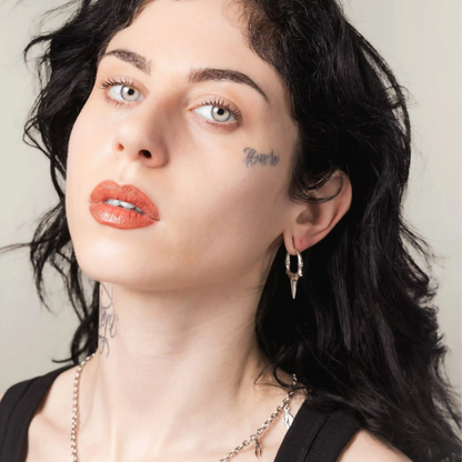 Model wearing silver Primal Blade Earrings with primal blade-shaped hoop details