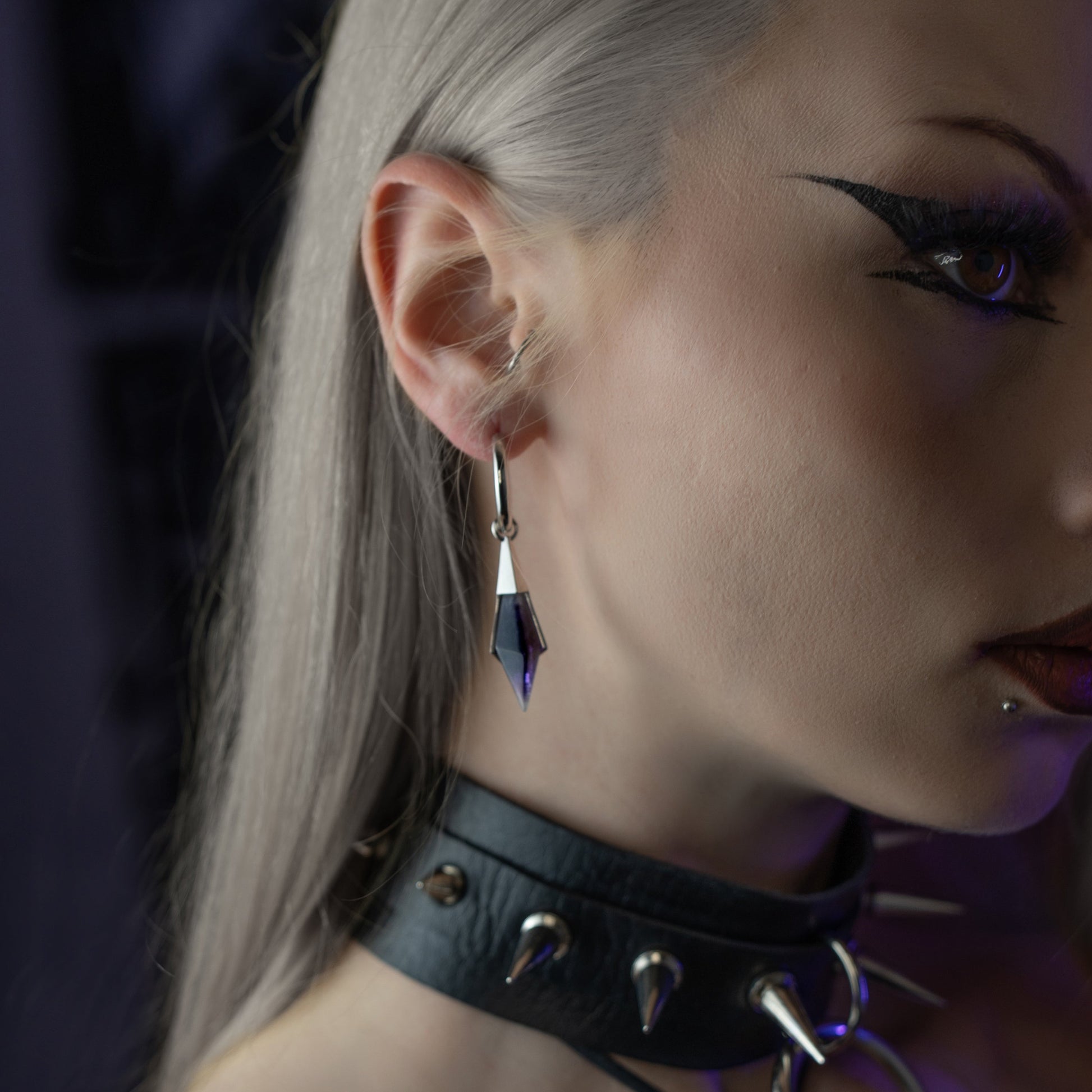 Model wearing the silver Prism Apex Earrings with blue crystal drops, styled with a black choker and dark alternative look.