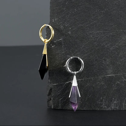 Silver and gold Prism Apex Earrings displayed on a dark stone surface, showing faceted crystal drops and clean geometric silhouettes.