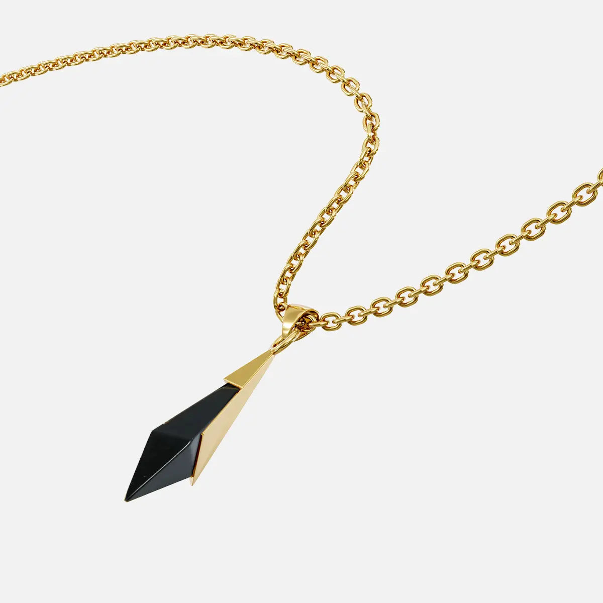 Close-up angled view of the gold-tone Prism Apex Necklace with a pointed black crystal pendant.