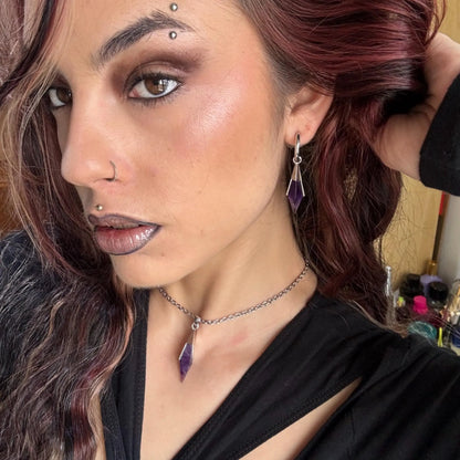Close-up of the silver-tone Prism Apex Necklace worn with a faceted purple crystal pendant.