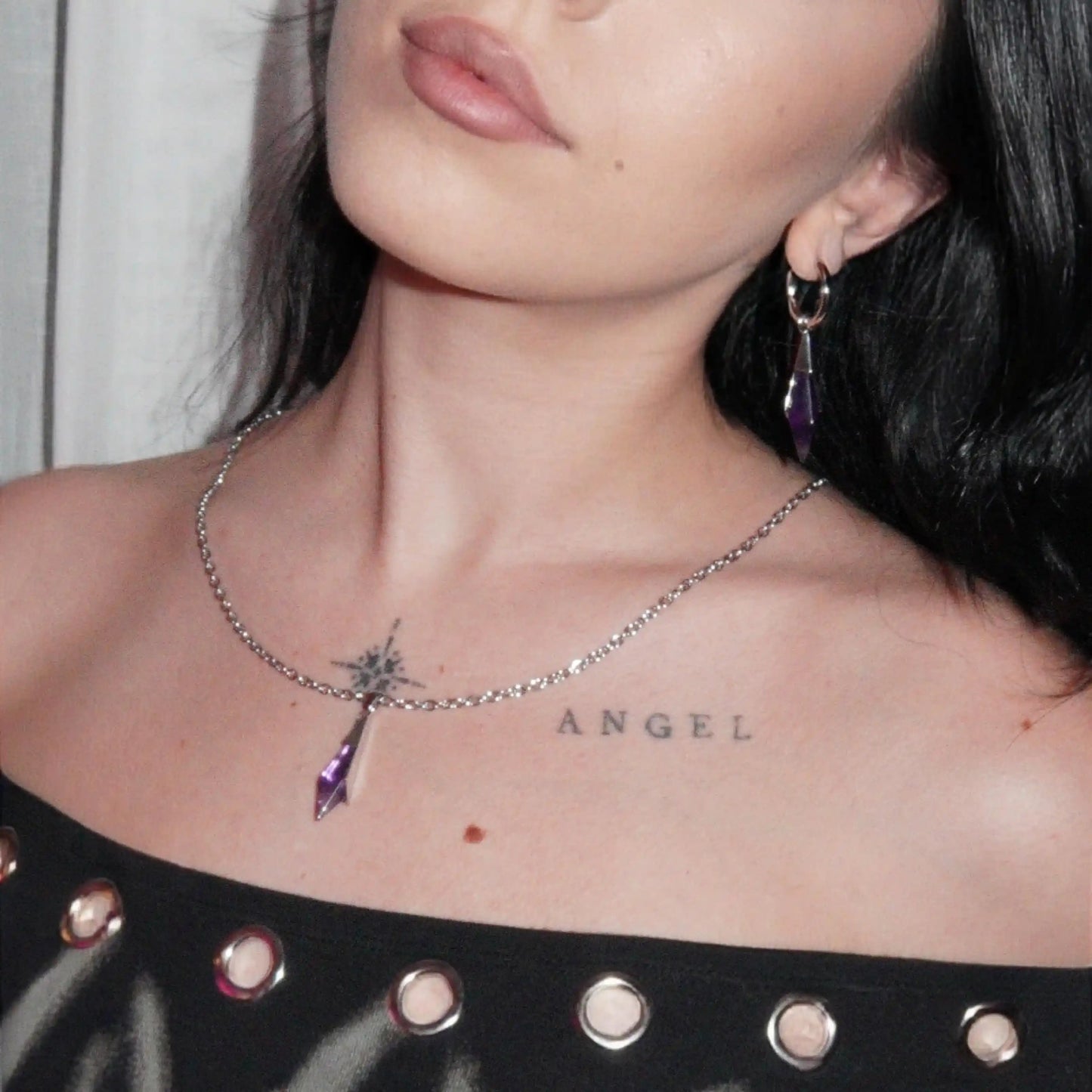 Silver-tone Prism Apex Necklace with a pointed purple crystal pendant worn at the center of the chest.