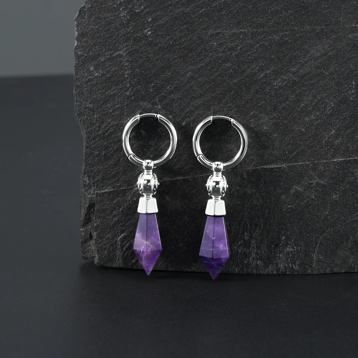 Silver Prism Orb Earrings displayed on a dark stone surface, featuring faceted amethyst crystal drops, orb bead details, and polished hoops.