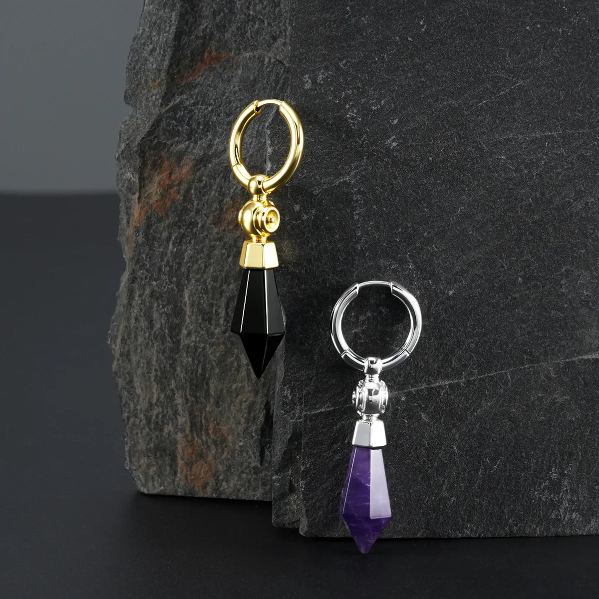 Silver and gold Prism Orb Earrings displayed on a dark stone surface, showing faceted crystal drops, spherical beads, and geometric styling.