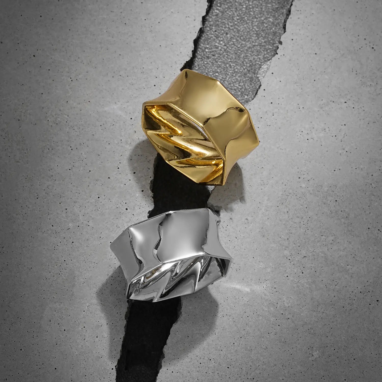 Large gold and silver Prismatic Harmony tunnels displayed on gray blocks