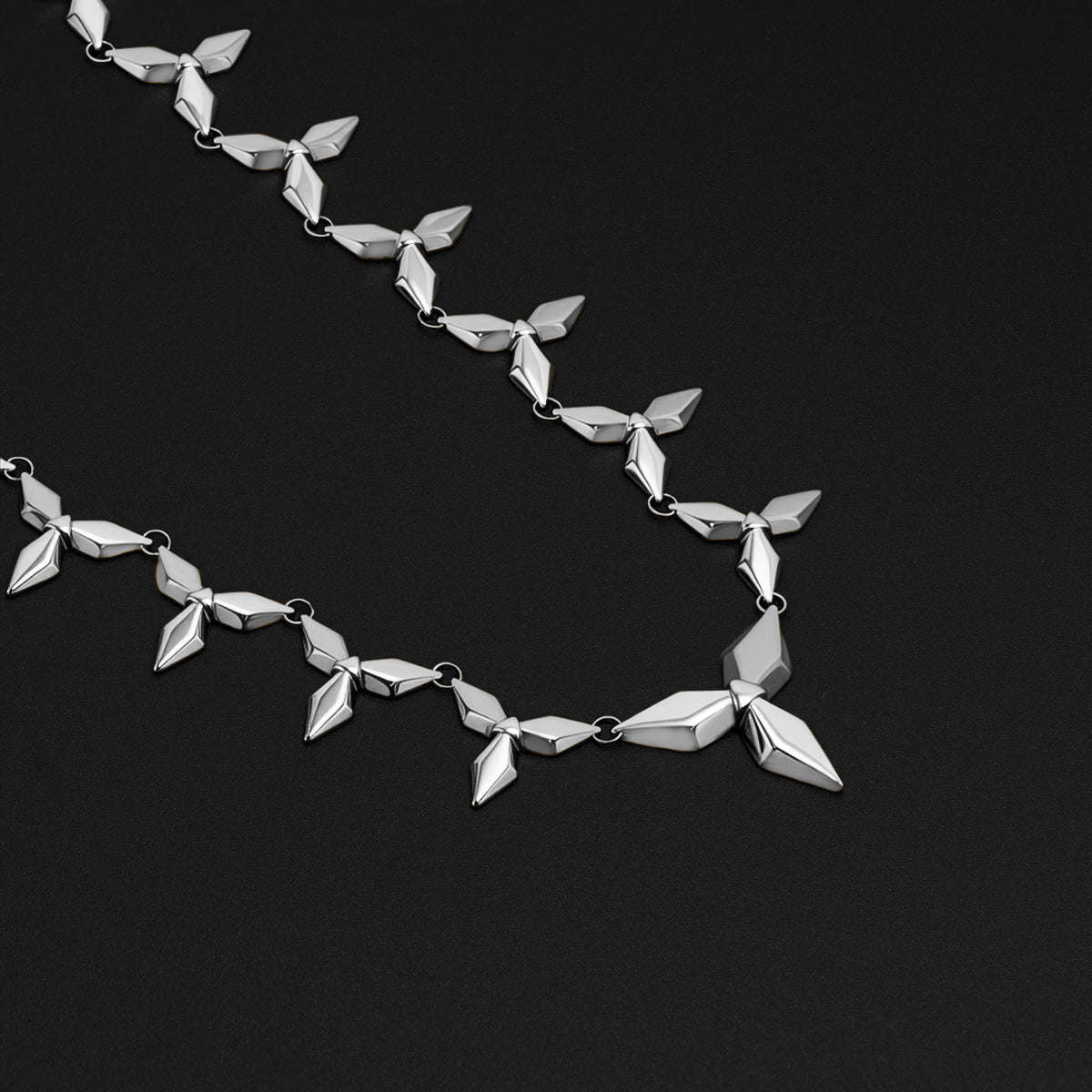 Silver Punk Petal necklace with matching stud earrings on black background