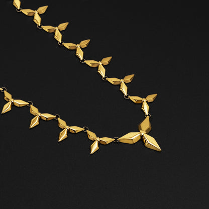 Gold Punk Petal necklace with pointed geometric links on black background