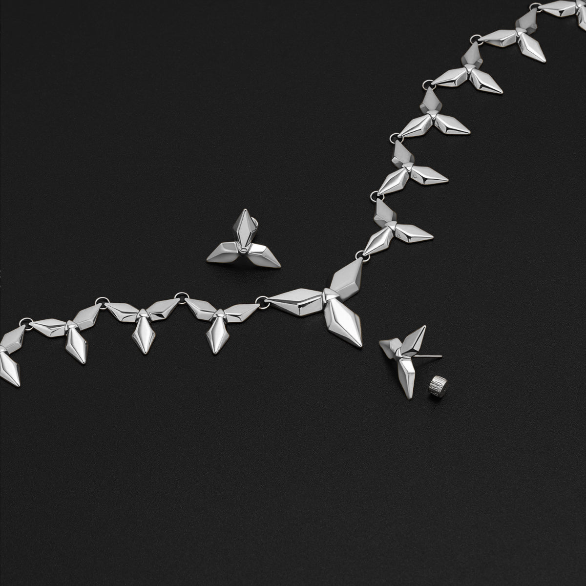 Silver Punk Petal necklace and stud earrings arranged on black background
