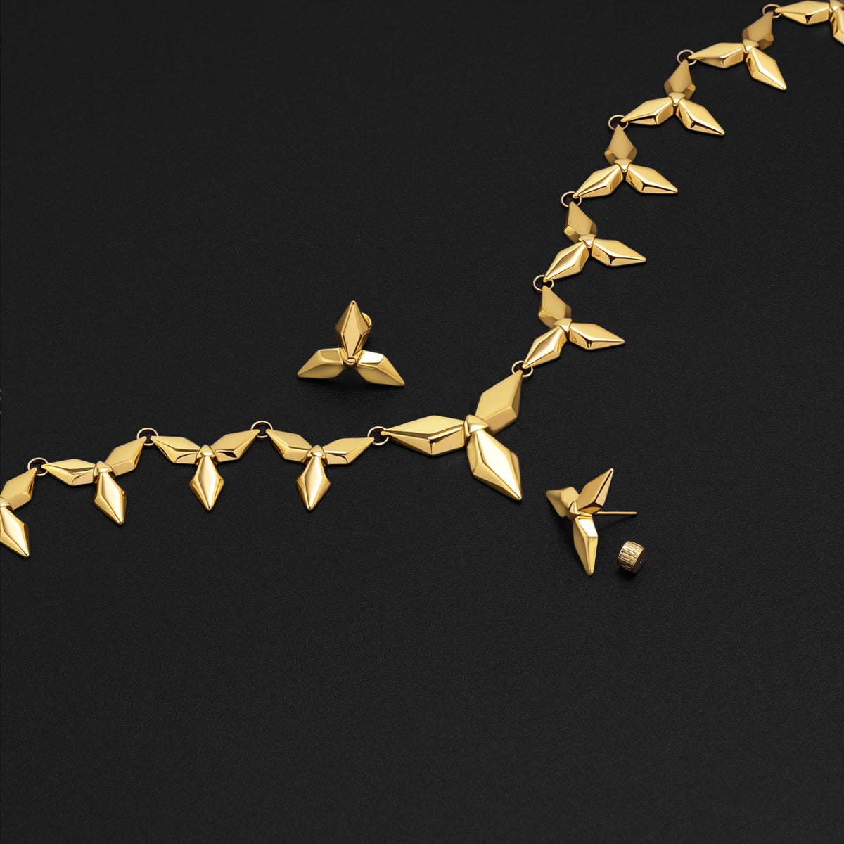 Gold Punk Petal necklace and stud earrings arranged on black background
