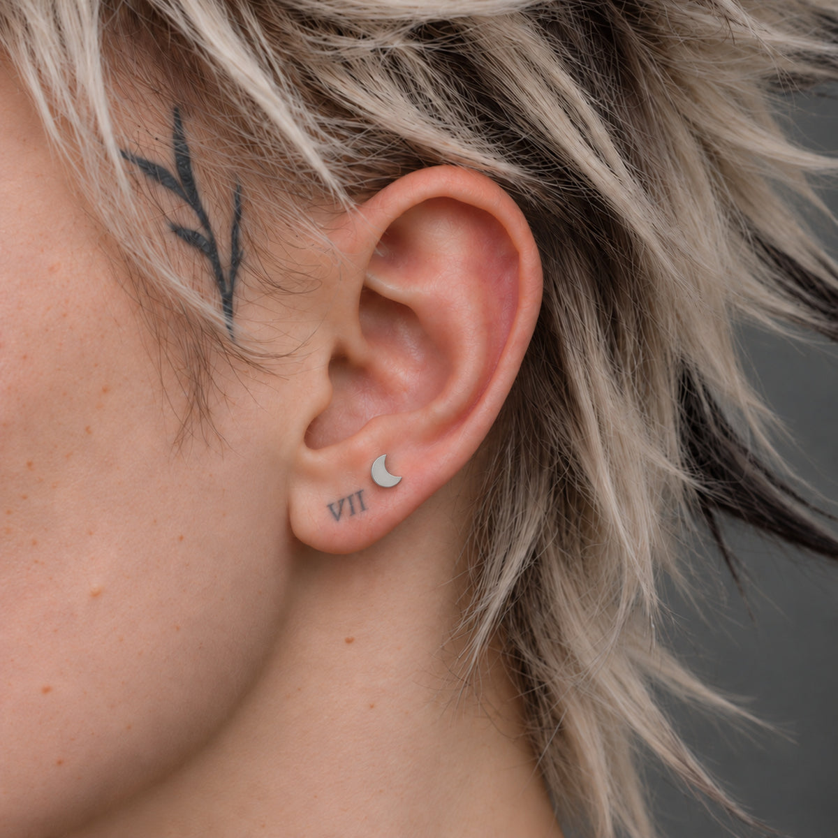 Crescent Titanium Flatback Stud worn alone on the approved ear model.