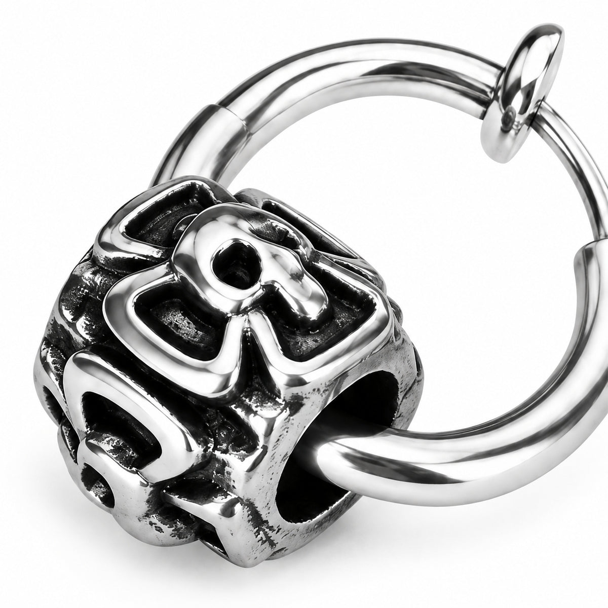 Close detail of the cast openwork skull bead and the slim hoop passing through its side aperture.