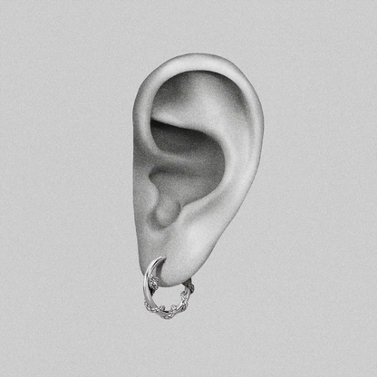 Illustrated ear graphic displaying a silver-tone hoop earring with a thorny vine texture