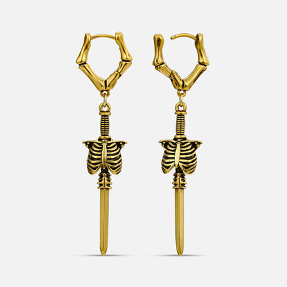Gold-tone bone hoop earrings featuring ribcage and blade pendants on white background