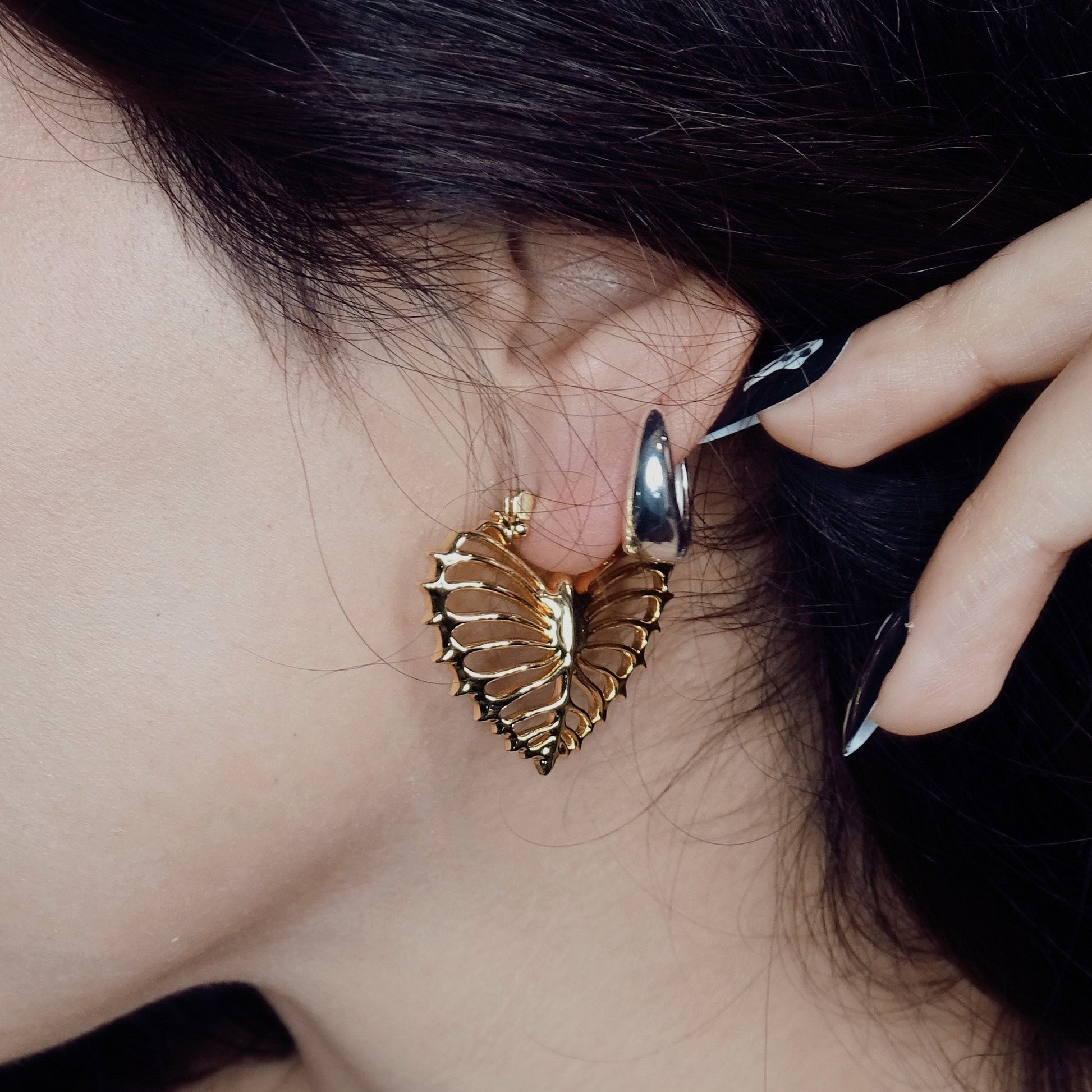 Close-up of gold Ribheart earring worn through a stretched lobe