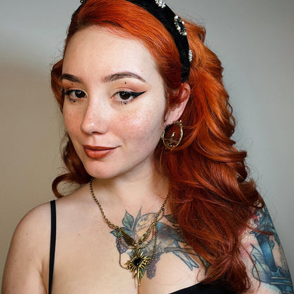 Red-haired model wearing a gold Rosebird hoop earring