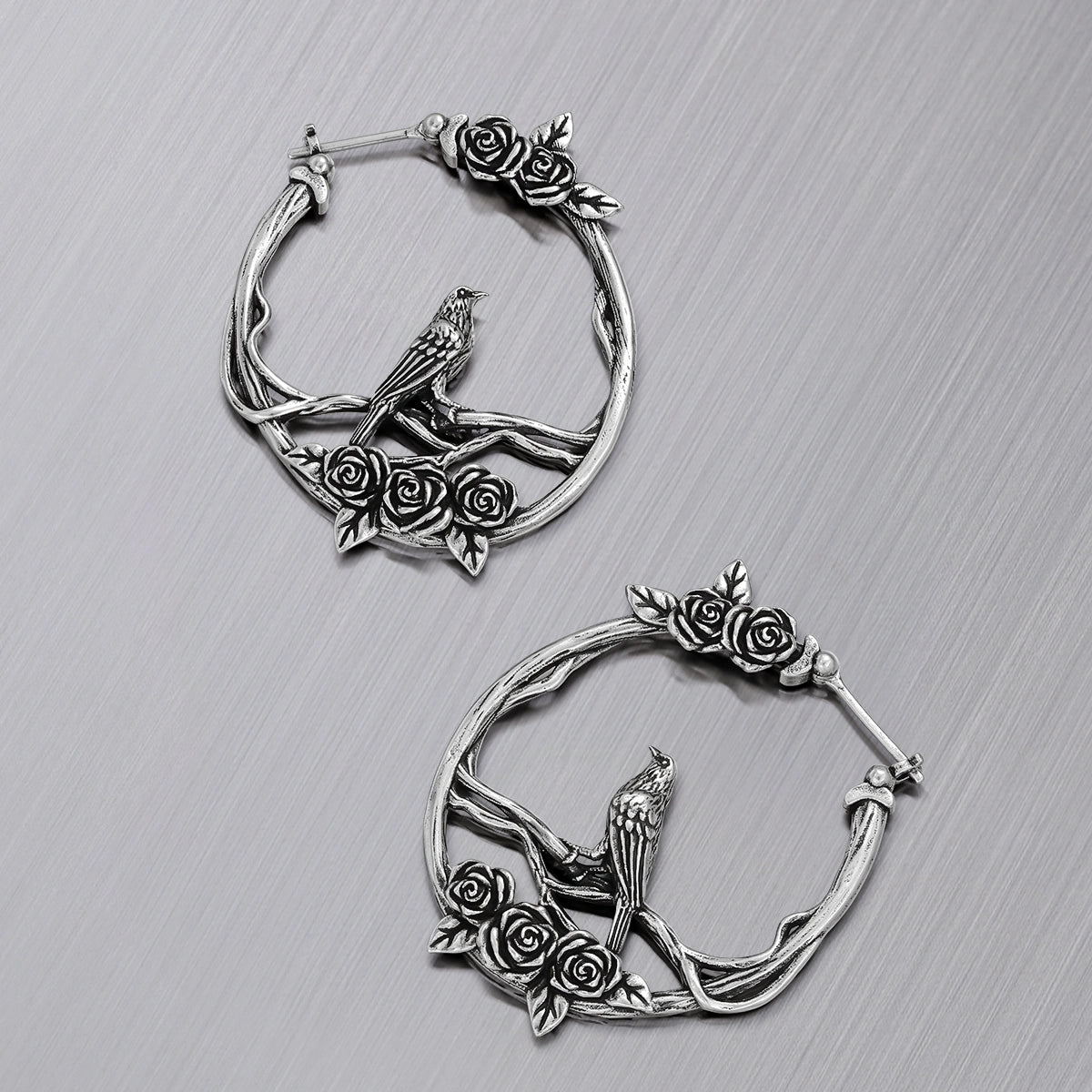 Pair of silver Rosebird hoop earrings shown open and closed