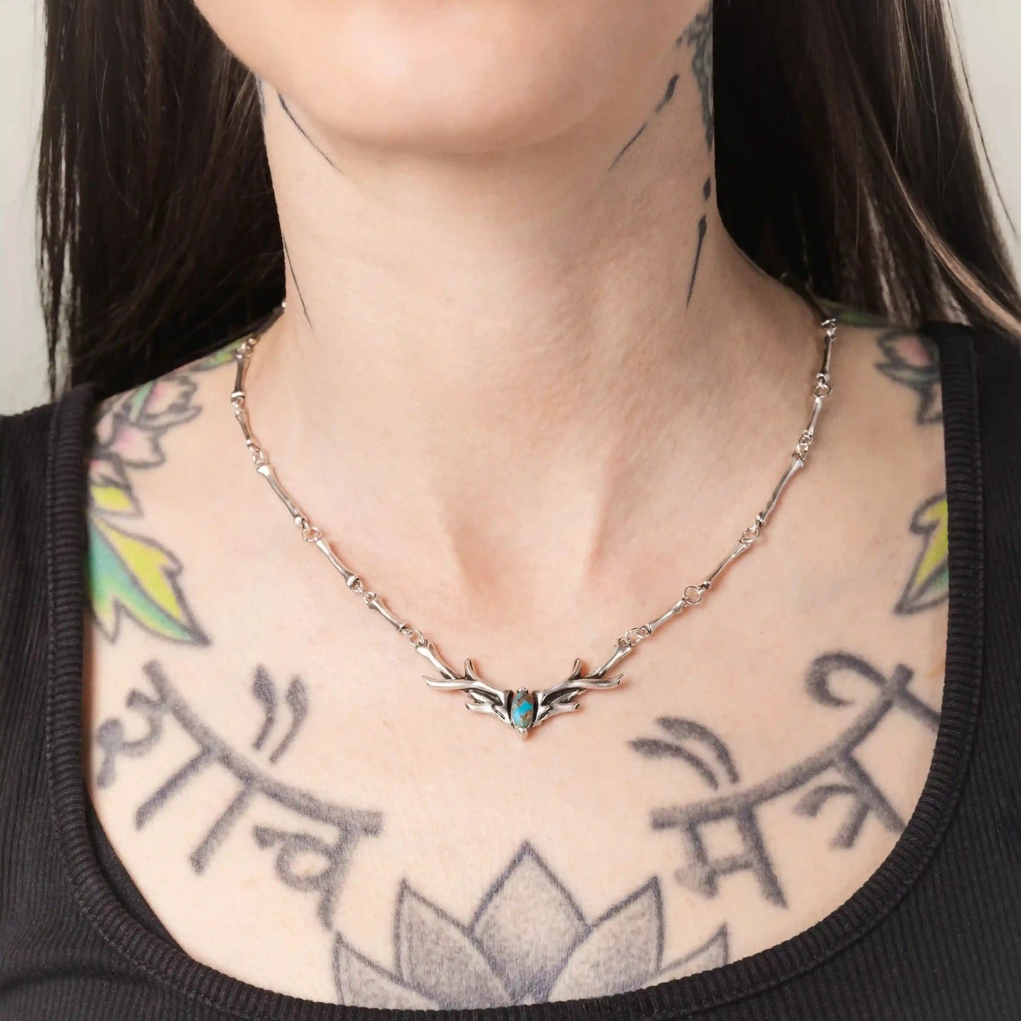 Model wearing the silver Sacred Antler Collar Necklace with turquoise stone and antler-shaped detailing