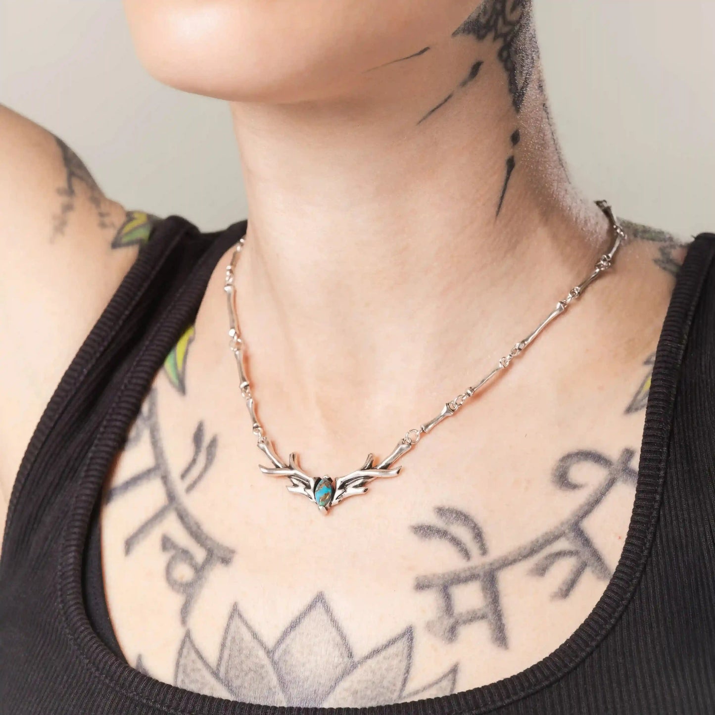 Side view of model wearing Sacred Antler Collar Necklace in silver with turquoise center stone