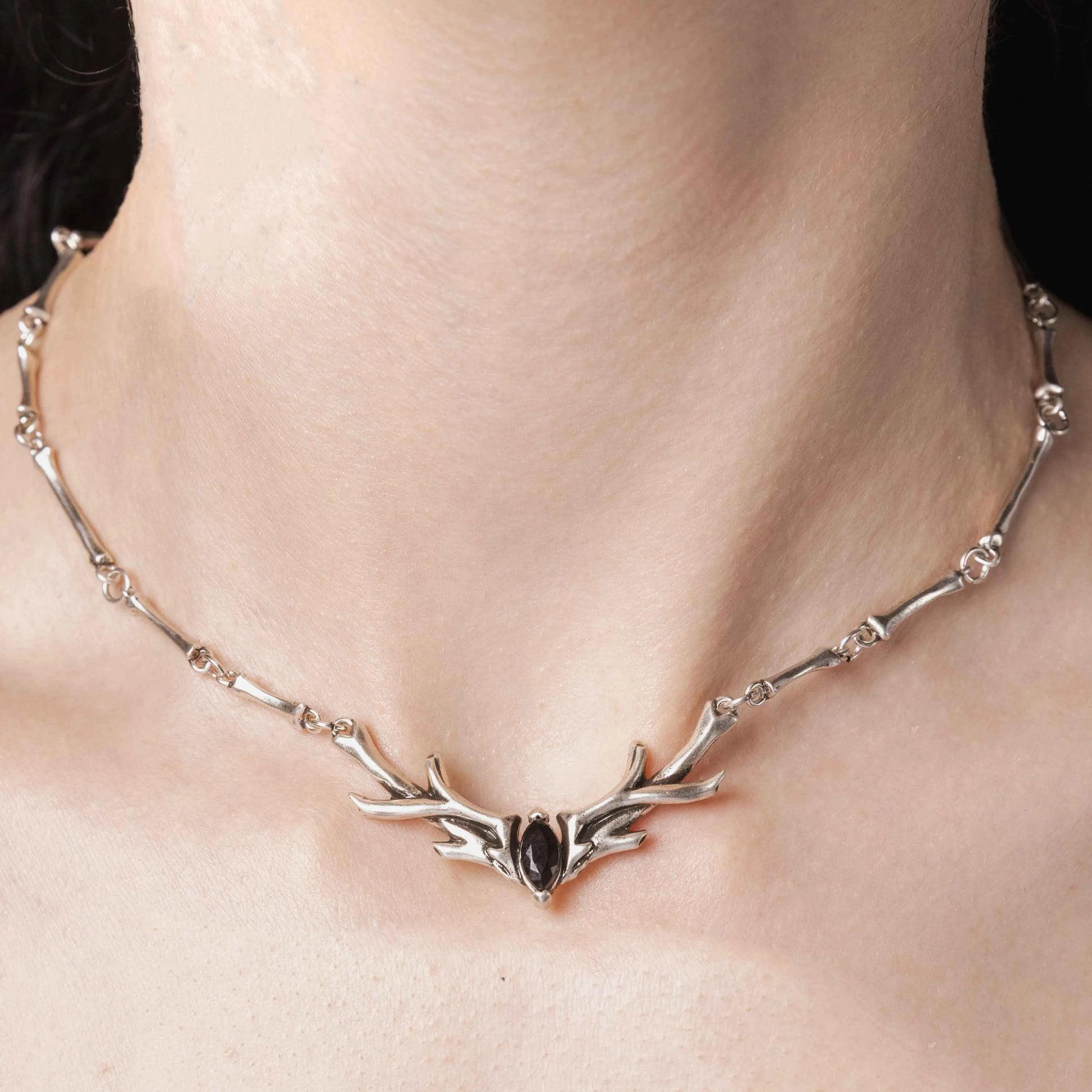 Model wearing the silver Sacred Antler Collar Necklace with black obsidian centerpiece, antler details, and dark forest-inspired styling.