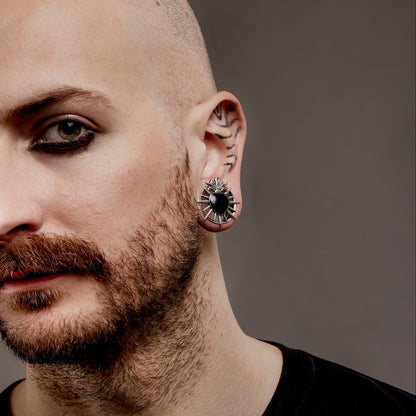Model wearing a silver Sacred Flame Heart tunnel in a stretched lobe