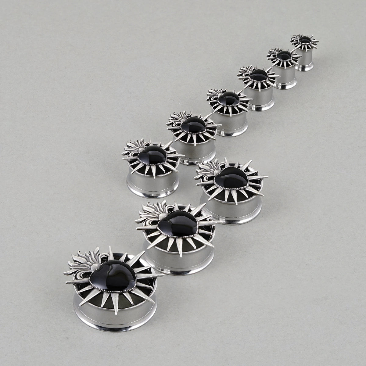 Sacred Flame Heart tunnels in graduated sizes arranged on a light surface