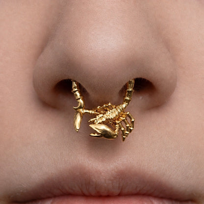 Gold-tone Scorpion Empowerment Clicker worn as a septum ring, showing its bold three-dimensional scorpion motif.