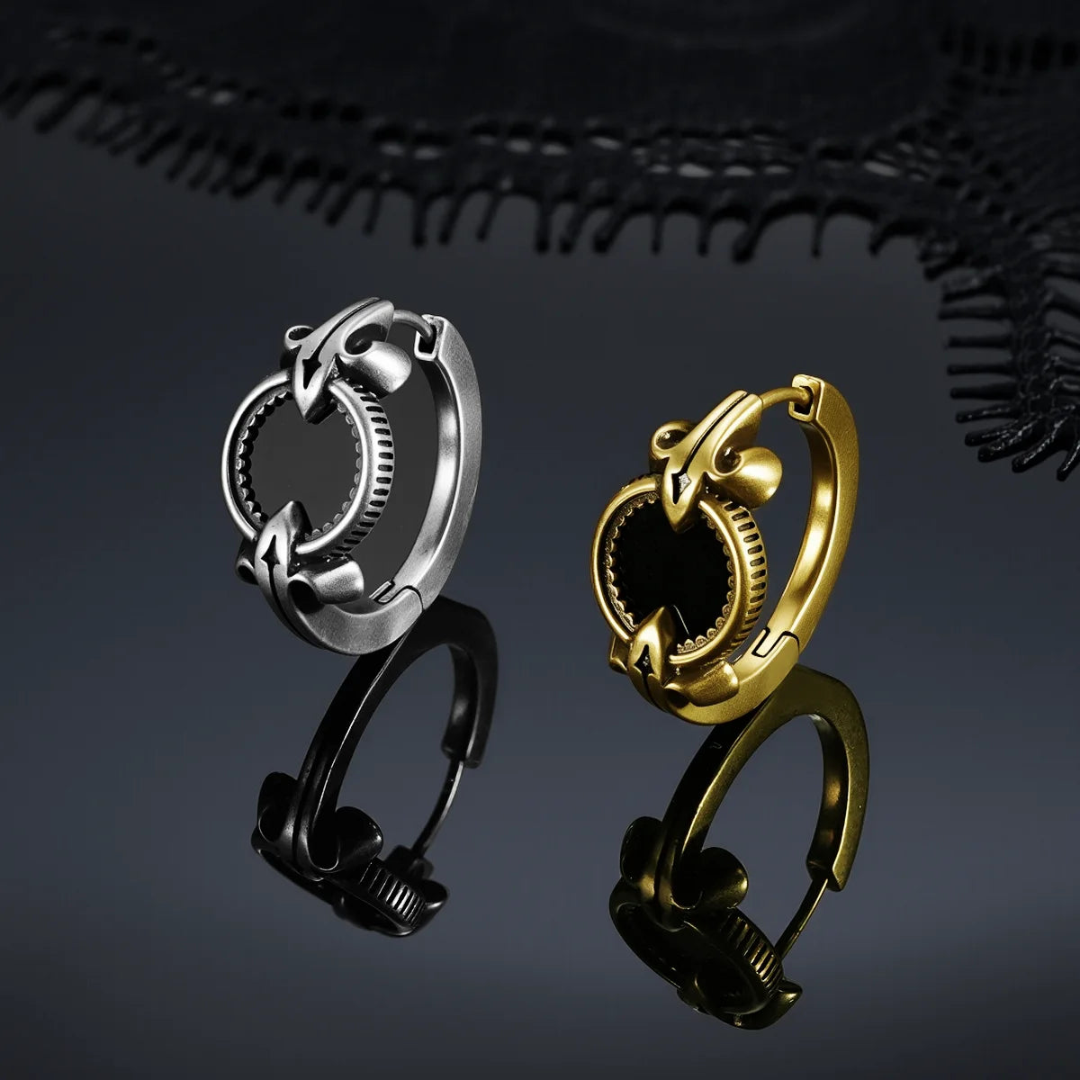 Antiqued silver- and gold-tone Scrying Mirror Hoop Earrings displayed upright on a dark reflective surface.