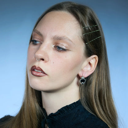 Side portrait showing an antiqued silver-tone Scrying Mirror Hoop Earring with a forward-facing black obsidian center.