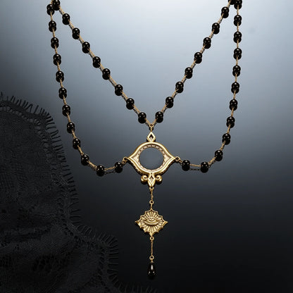 Gold-tone Scrying Mirror Necklace displayed against black lace on a dark reflective surface.