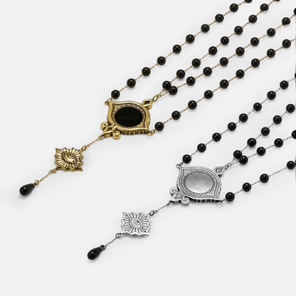 Antiqued silver- and gold-tone Scrying Mirror Necklaces displayed from angled views to show the black bead chains and symbolic drops.
