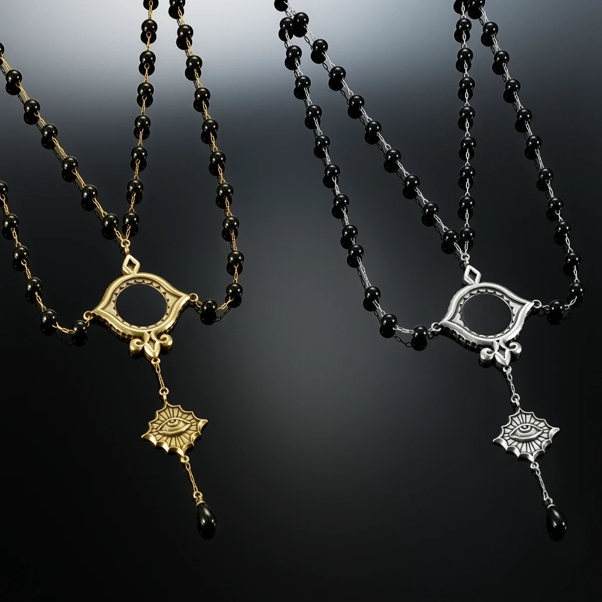 Antiqued silver- and gold-tone Scrying Mirror Necklaces displayed together against black lace on a dark reflective surface.