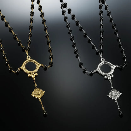 Antiqued silver- and gold-tone Scrying Mirror Necklaces displayed together against black lace on a dark reflective surface.